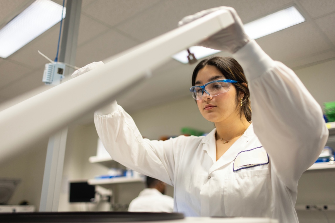 Scientist using a centrifuge for sample processing.