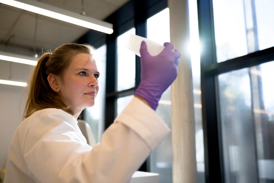 Scientist inspecting samples in the laboratory for CellCarta genomics services.