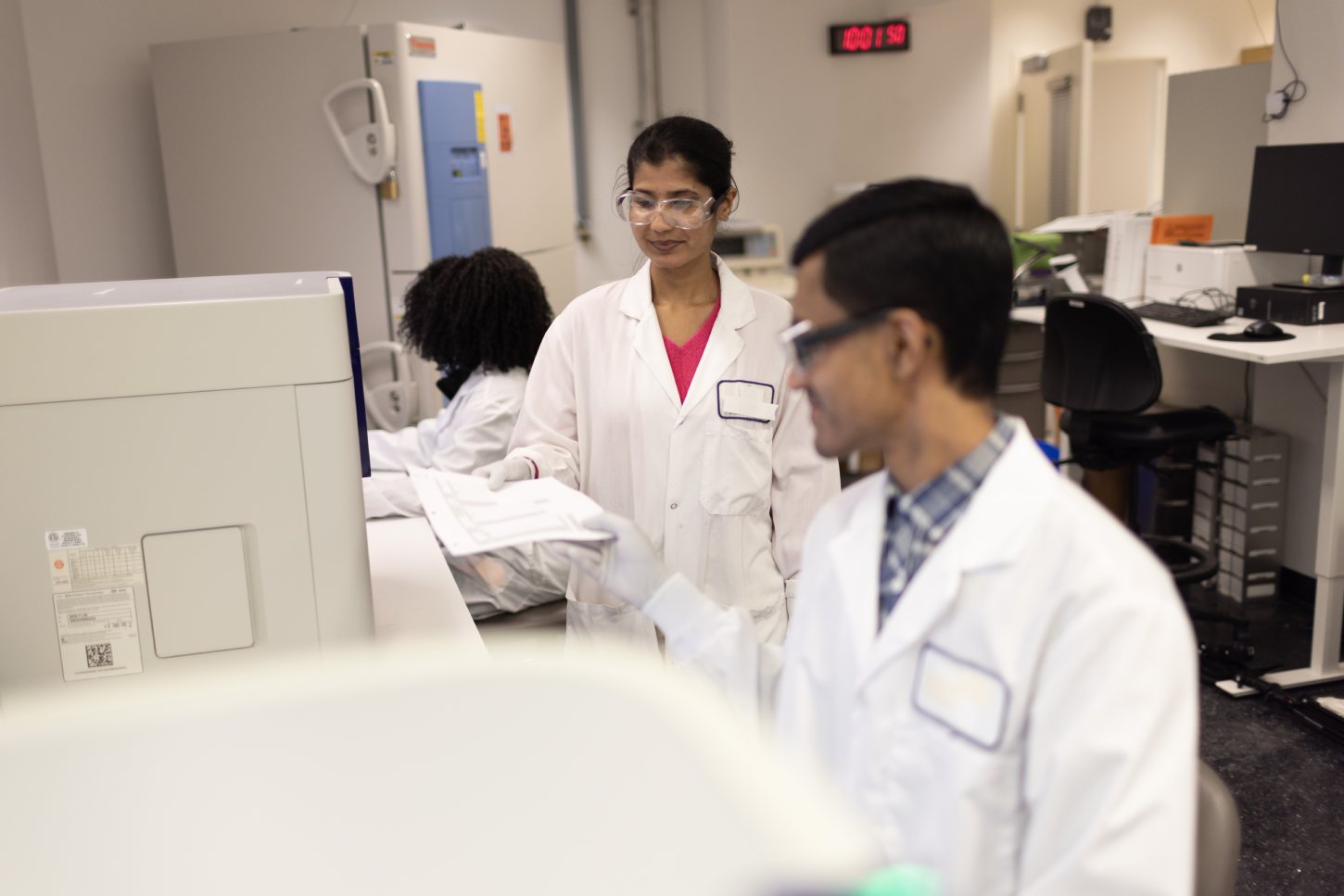 CellCarta scientists in clinical laboratory reviewing cell proliferation data