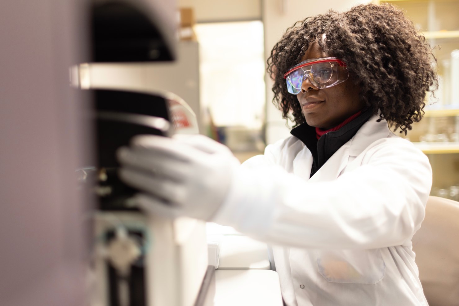 Scientist operating flow cytometry instrument in CAP/CLIA-accredited laboratory