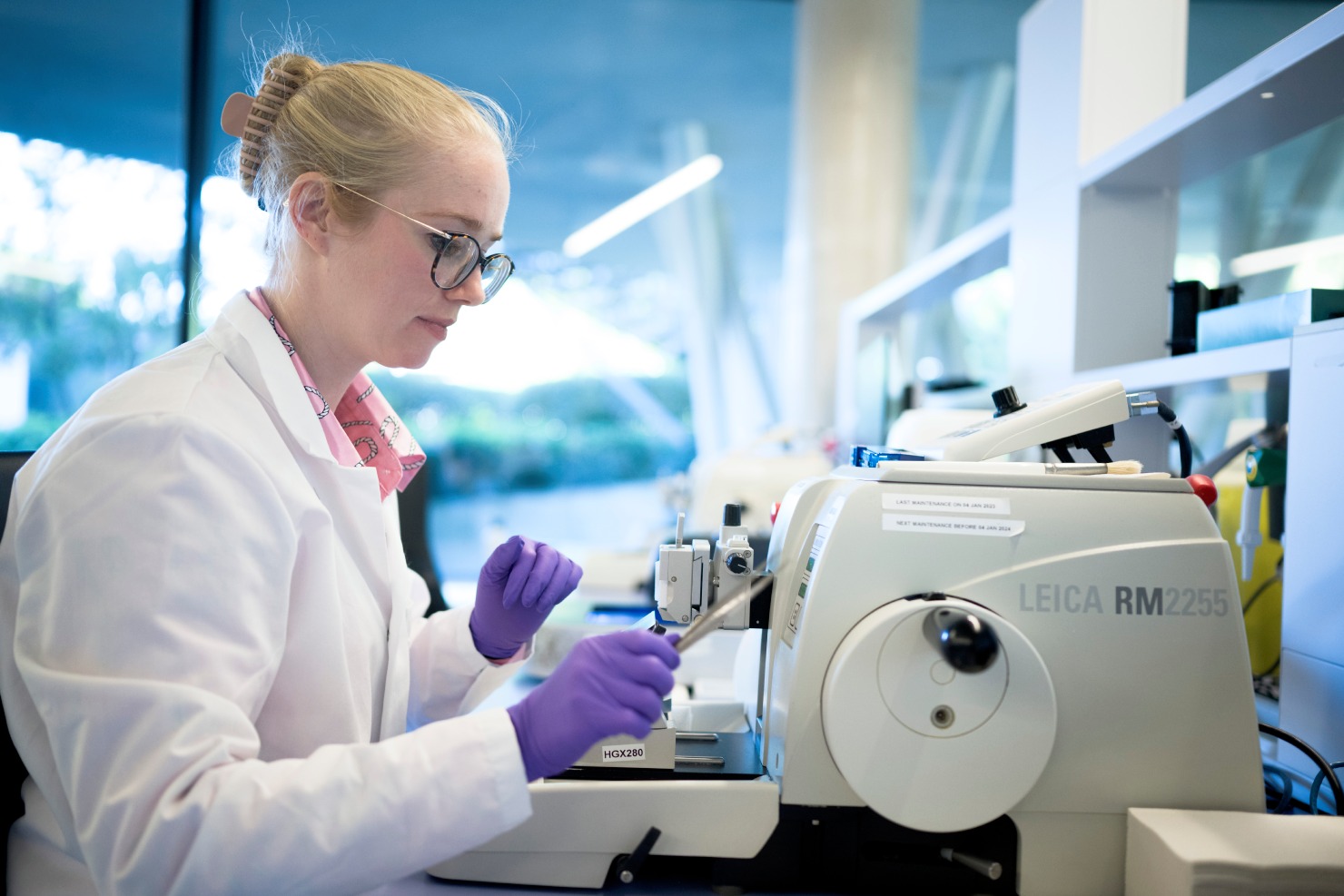 Scientist operating a Leica rotary microtome to section tissue blocks for CellCarta IHC services.