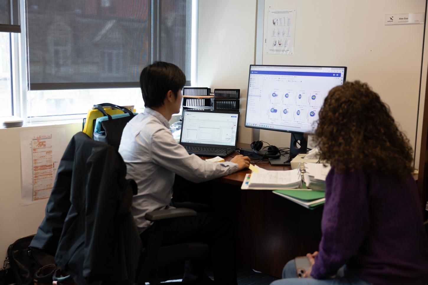 CellCarta scientists reviewing clinical trial data together at a workstation.