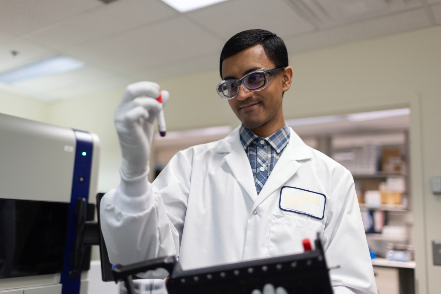 Scientist inspecting a blood sample for CellCarta liquid biopsy platform.