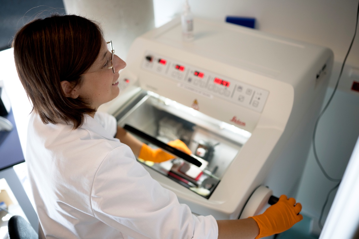 Scientist operating a benchtop laboratory instrument.