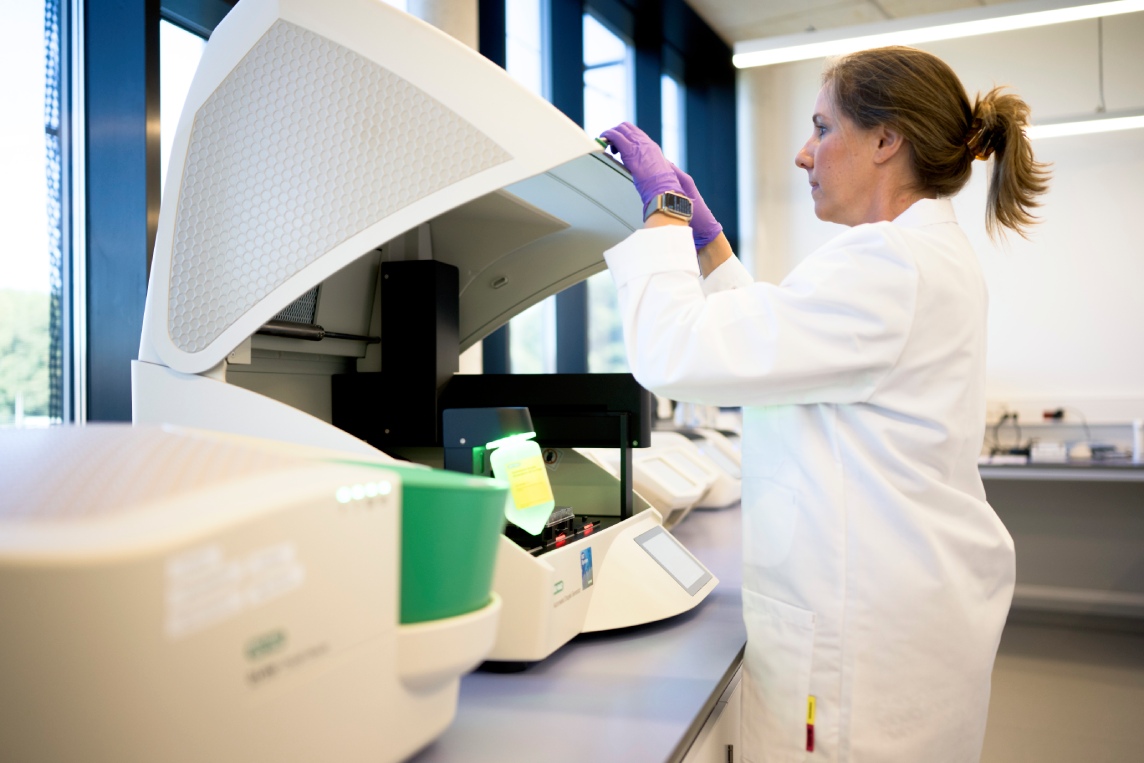 Scientist loading samples into a benchtop instrument.