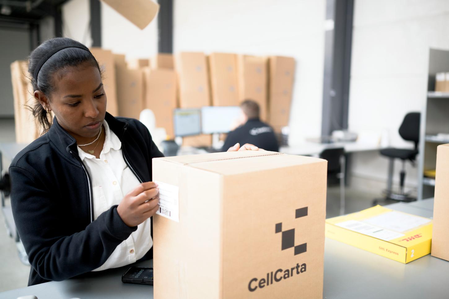 Scientist packing a CellCarta sample box.