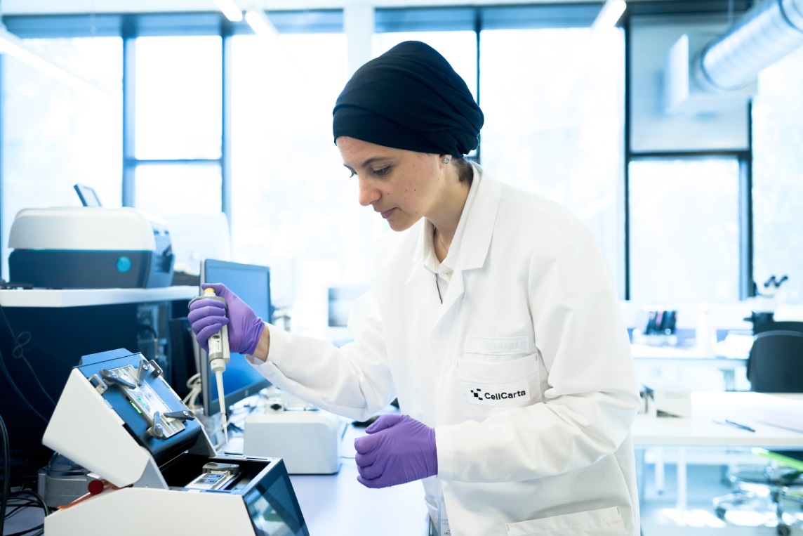 Scientist working at a laboratory bench and instrument.