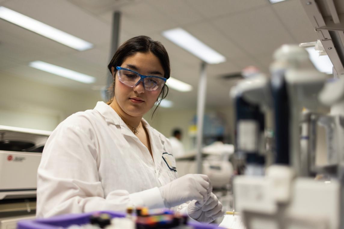 Scientist recording results at a laboratory bench.