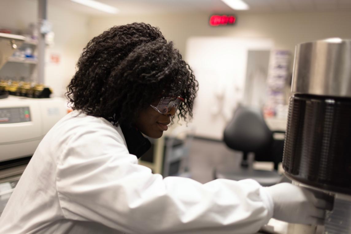 Scientist processing flow samples at an open bench.