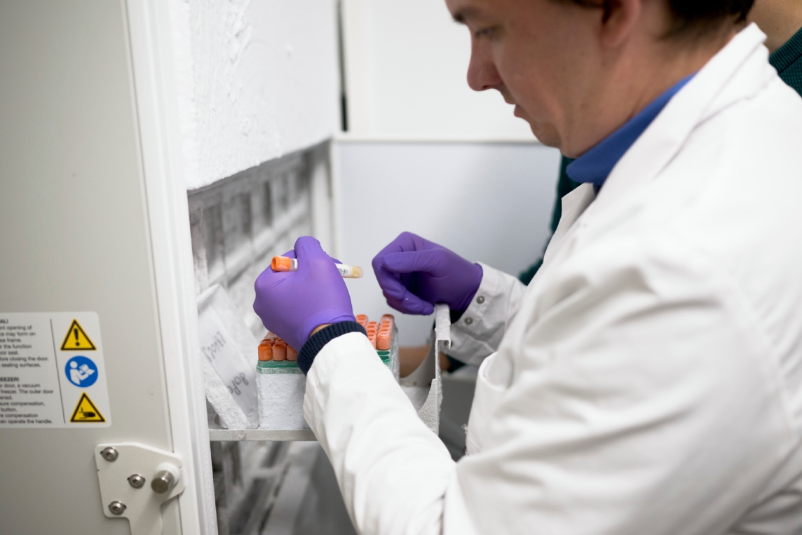 Scientist handling samples at a -80 degree celsius freezer.