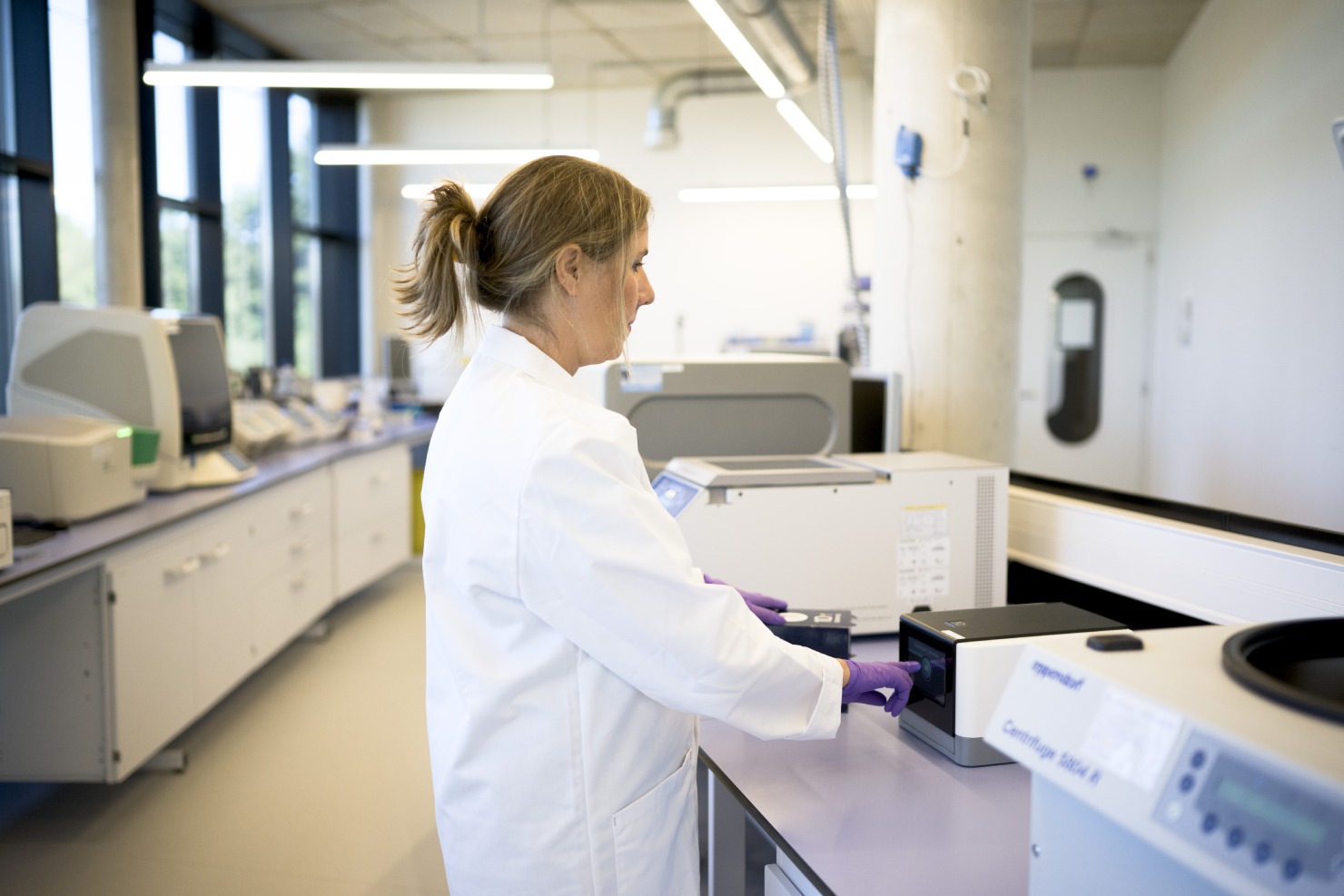 Scientist operating next-generation sequencing instrument in a CellCarta genomics laboratory