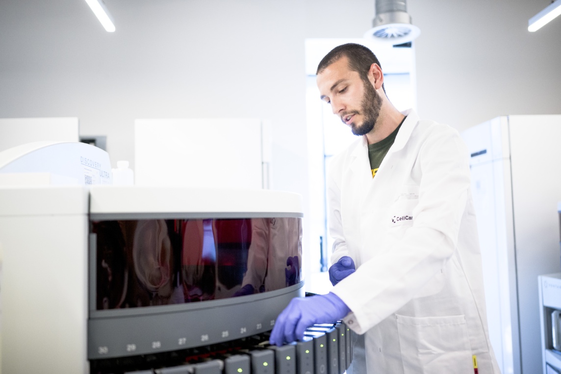 Scientist operating an automated immunohistochemistry staining instrument in a CellCarta histopathology laboratory