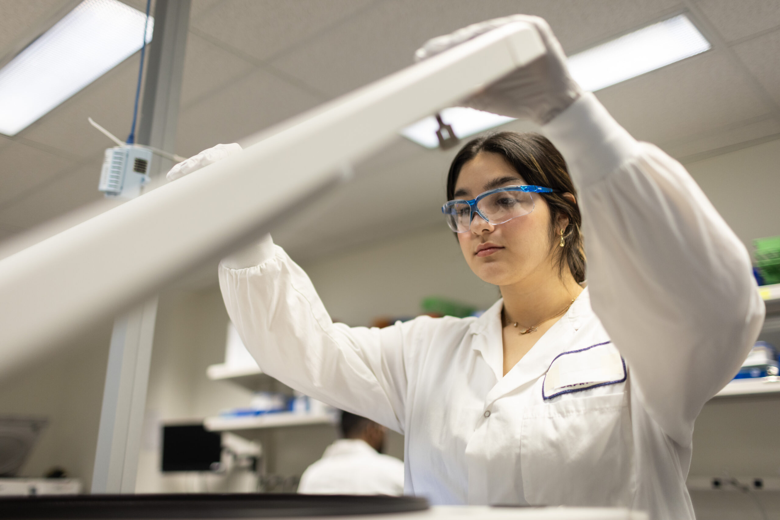 Scientist using a centrifuge for sample processing.