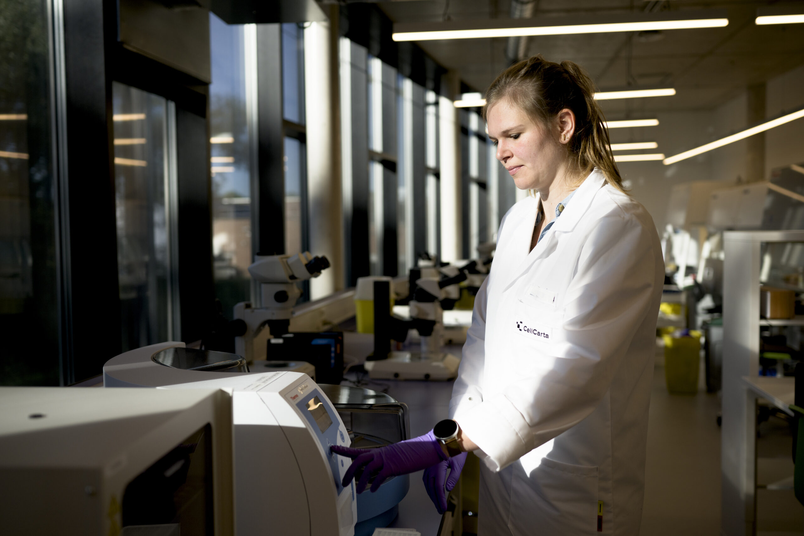 Scientist working beside laboratory instruments.