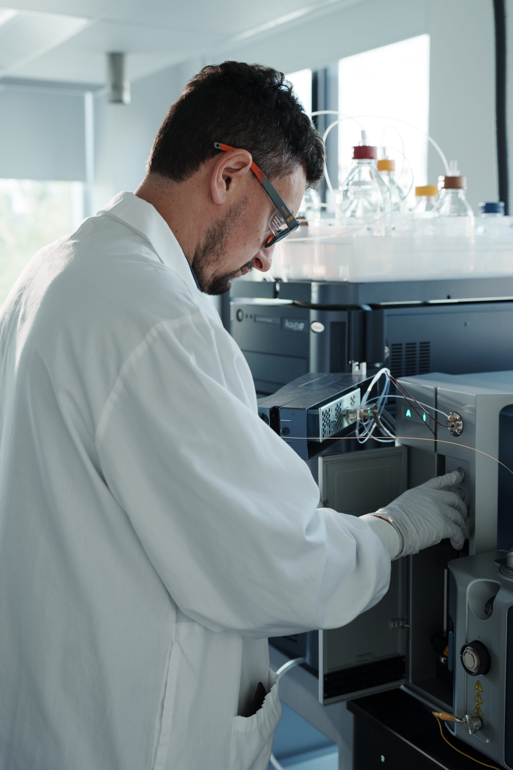 Scientist at mass spectrometry workstation analyzing protein biomarker targets from clinical samples