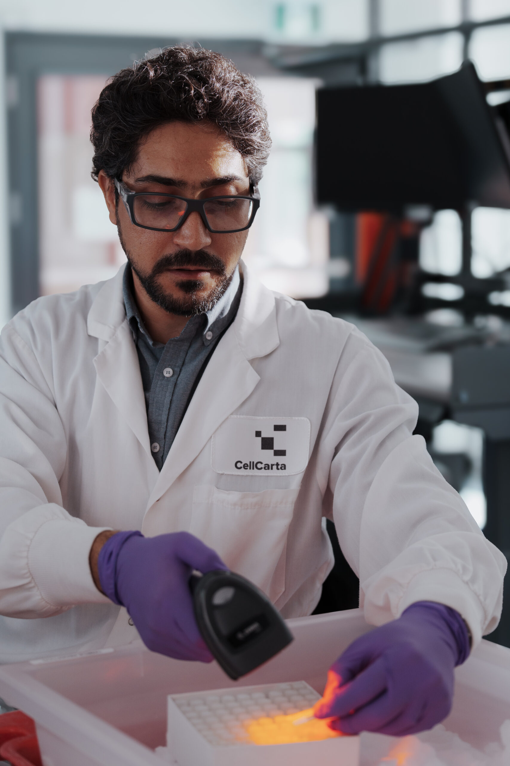 Scientist inspecting a sample vial in the laboratory.