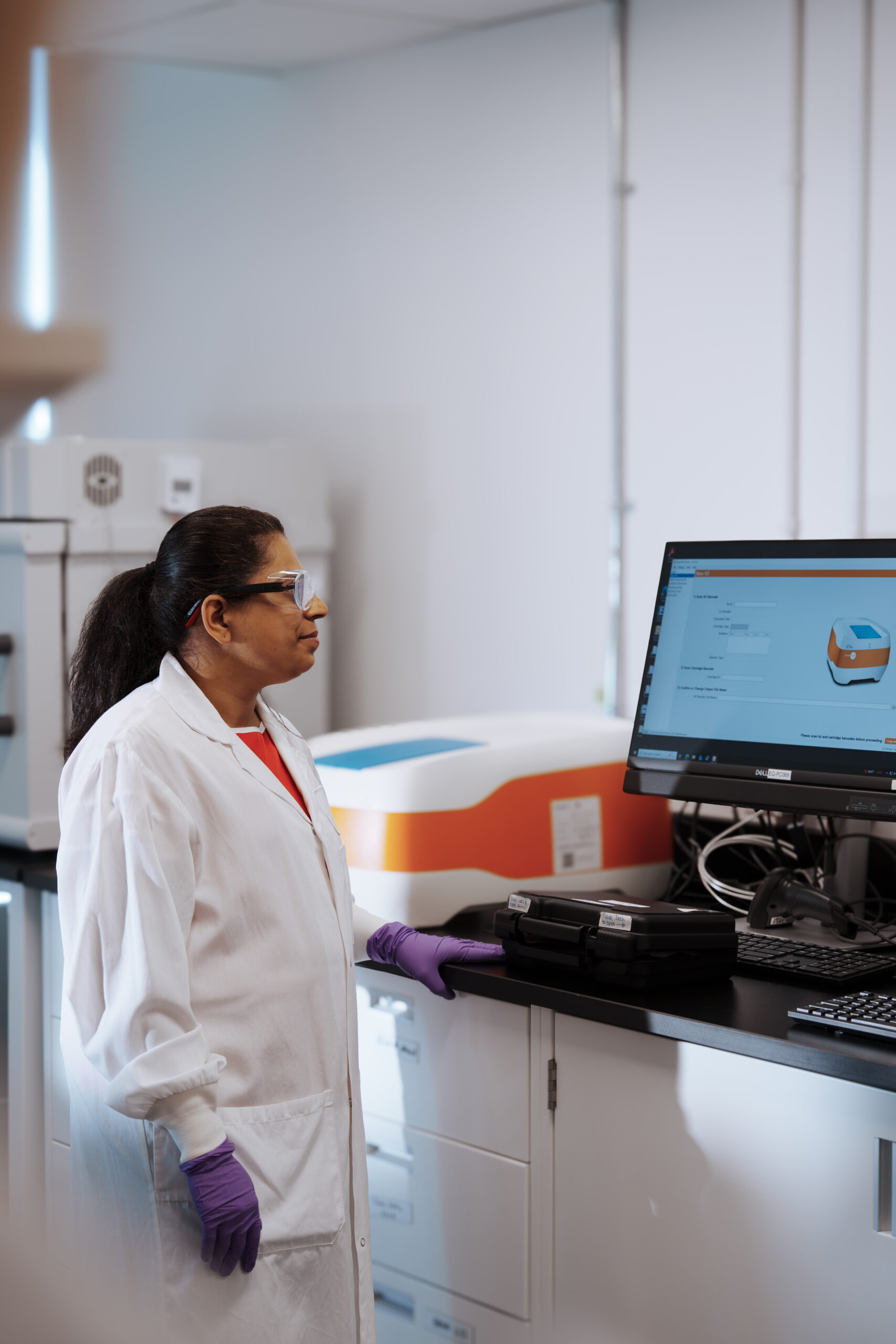 Scientist operating Ella™ automated ELISA multiplexing system