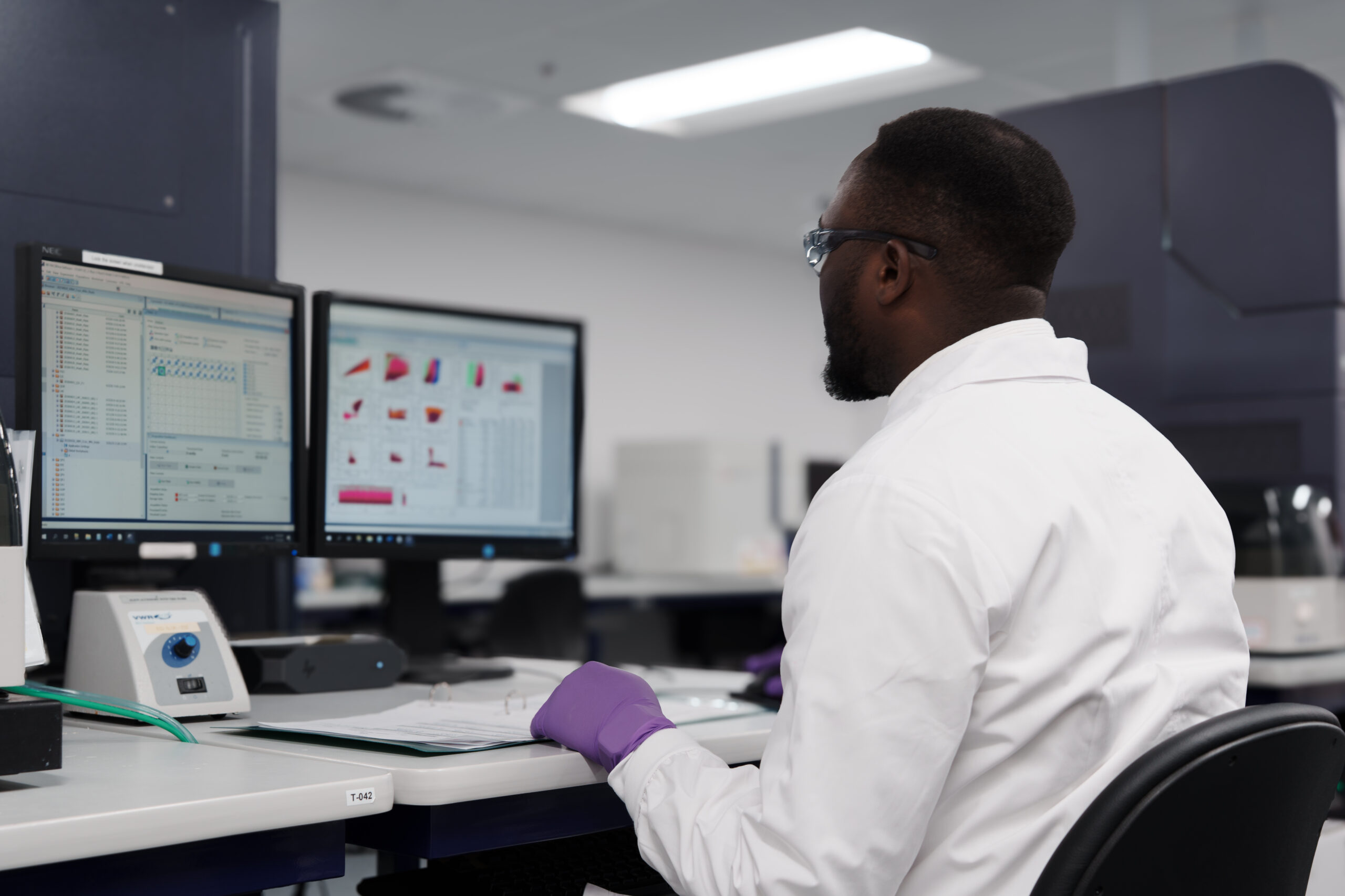 Scientist reviewing data on a laboratory monitor using CellEngine.
